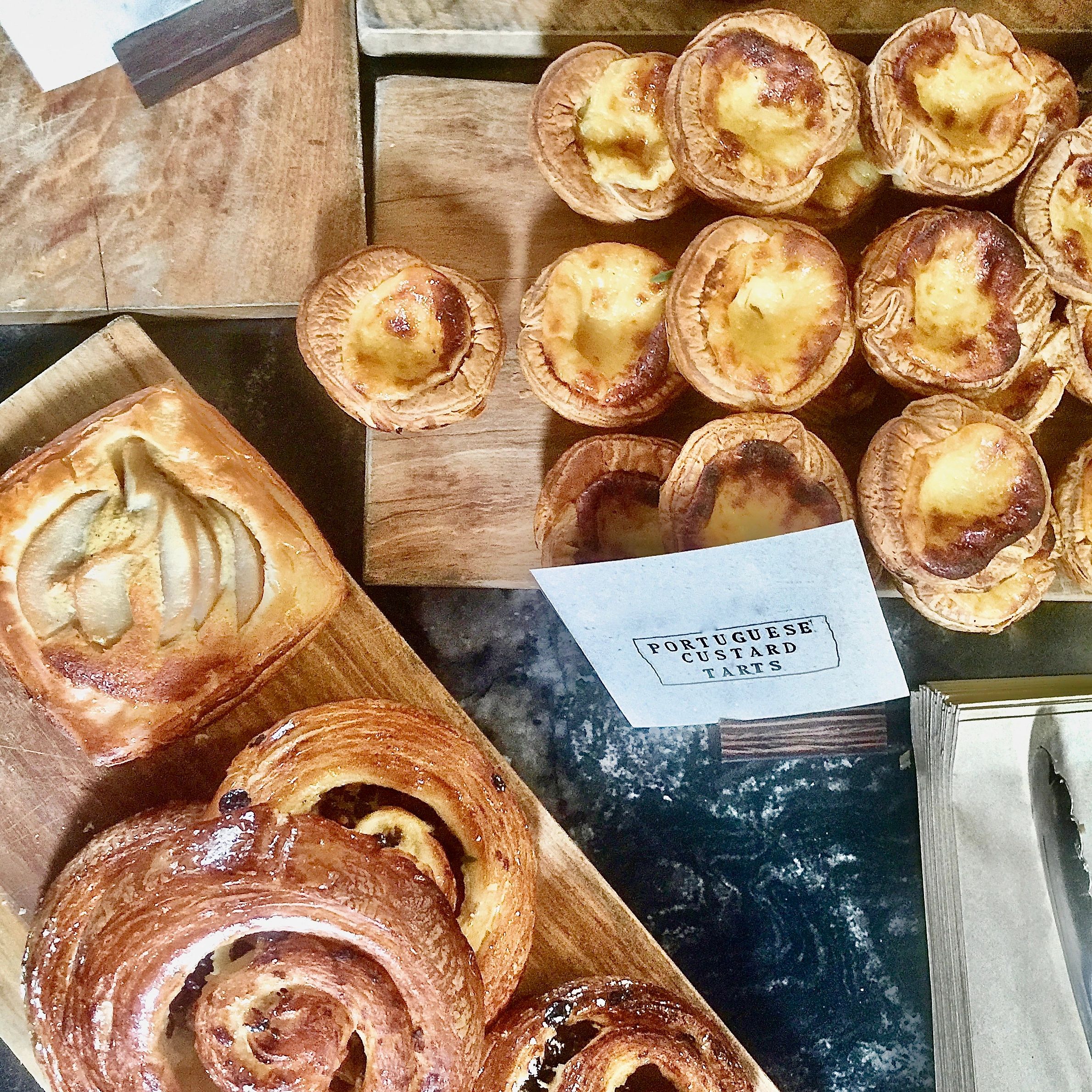 Portuguese custard tarts on a bakery tray