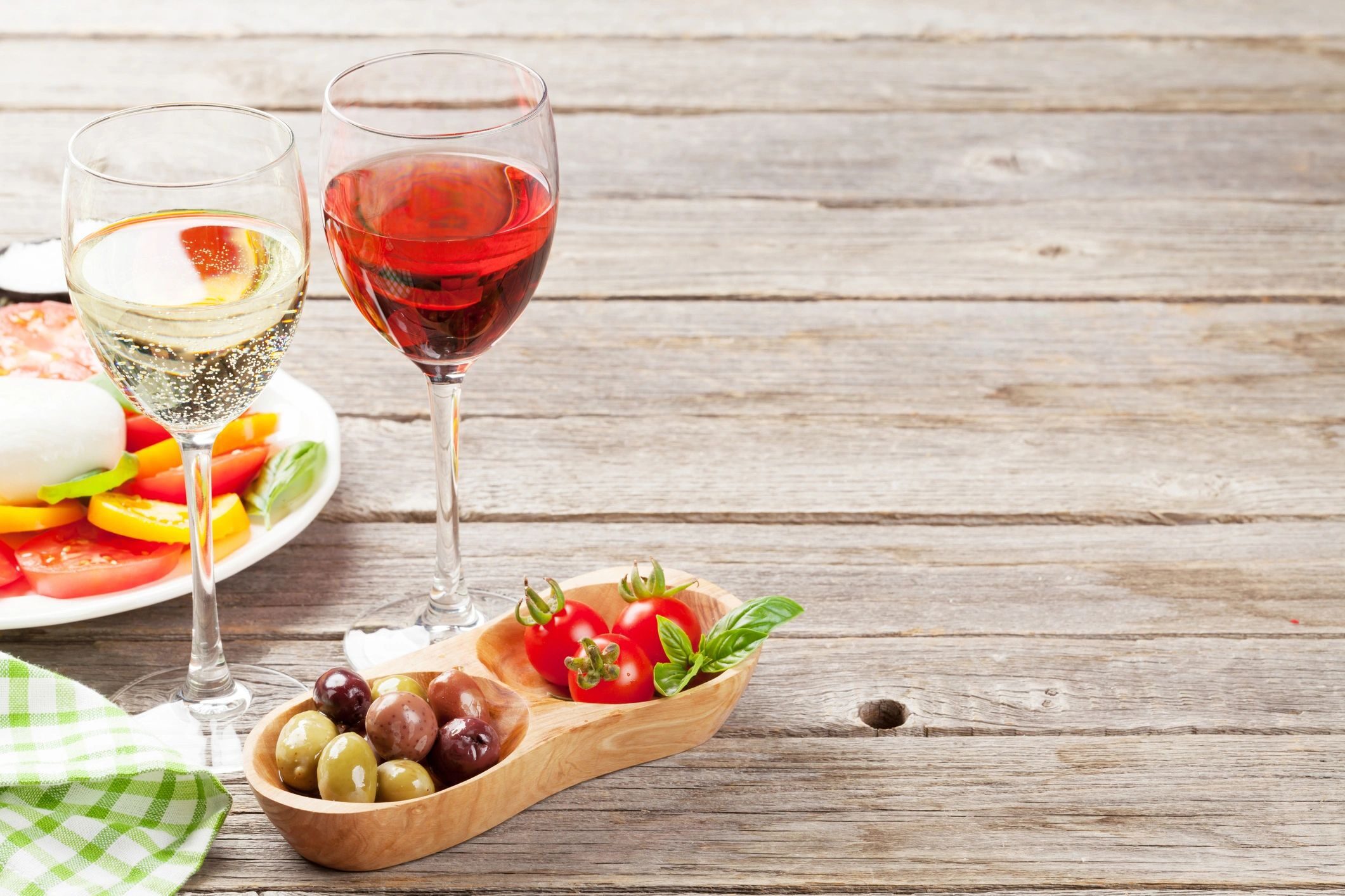White and rose wine glasses with caprese salad